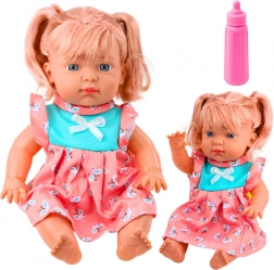 Poppenbaby in kleurrijke jurk met flesje en geluiden