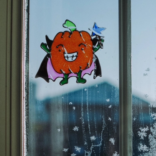 Glitterende kleurrijke Halloween-raamdecoratie in de vorm van een pompoen