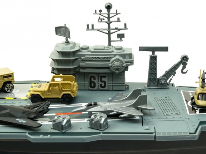 Groot militair vliegdekschip met vliegtuigen en voertuigen