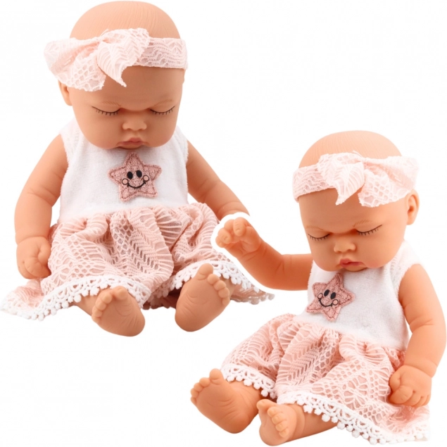 Pop slapende baby in roze jurk met kant en sterren hoofdband
