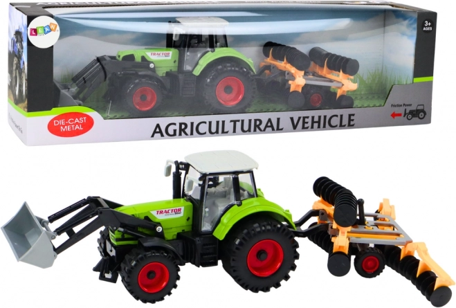 Tractor met schijveneg en frontlader groen