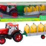 Grote tractor met aanhanger en pakken hooi